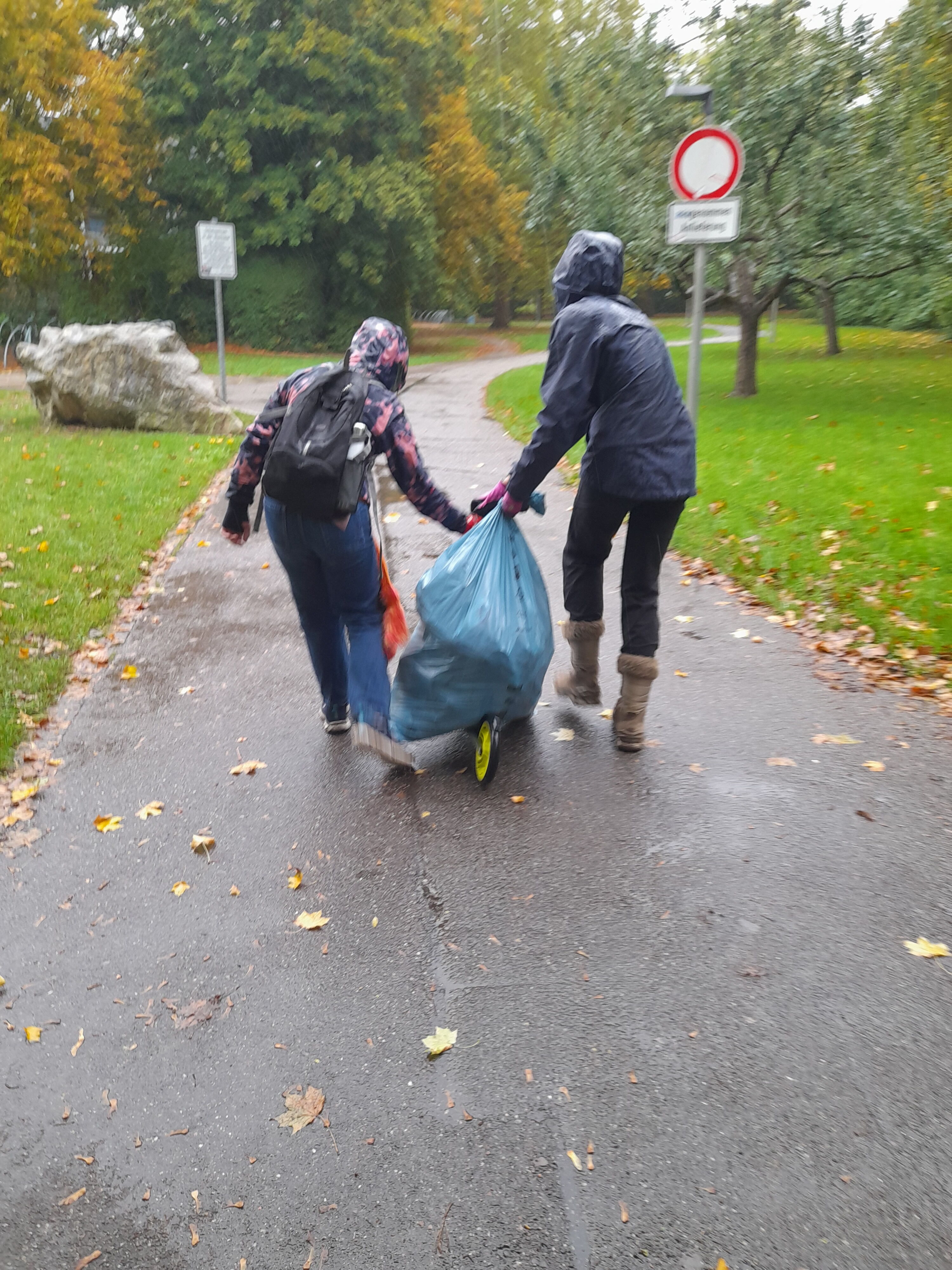 zwei Schüler der Umwelt AG tragen Müllsack